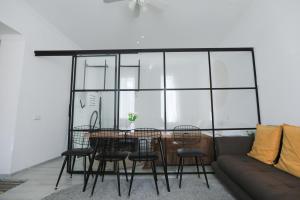 a dining room with a table and chairs and a couch at Kutaisi Heritage - Modern House in Historic District in Kutaisi