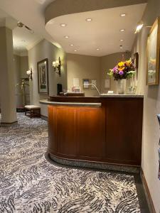 a hotel lobby with a reception desk and flowers at Kingston Hotel in Vancouver