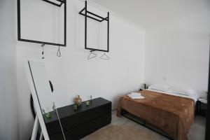 a bedroom with a bed and a mirror at Kutaisi Heritage - Modern House in Historic District in Kutaisi