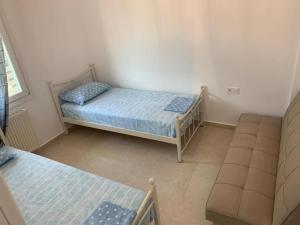 1 dormitorio pequeño con 2 camas y sofá en Petrino Apartments, en Kavala