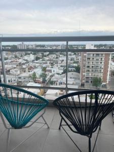 a balcony with two chairs and a view of a city at Dpto zona céntrica con yacuzzi in San Lorenzo