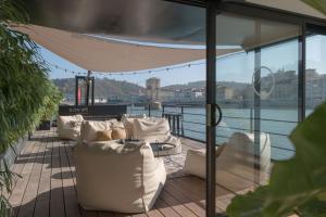 a balcony with white furniture and a view of the water at LA PENICHE - Bed And Bicycle - Vienne in Vienne