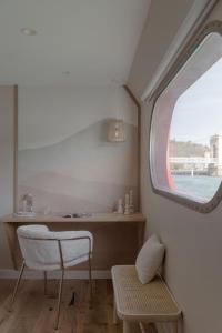 a small room with a window and a chair at LA PENICHE - Bed And Bicycle - Vienne in Sainte-Colombe