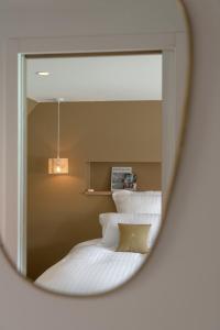 a mirror reflection of a bed with white pillows at LA PENICHE - Bed And Bicycle - Vienne in Sainte-Colombe