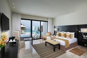 a bedroom with a bed and a living room at The Sens Tulum Riviera by Oasis in Akumal