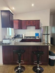 a kitchen with a counter and two bar stools at Guest House with Shared Pool Access in David