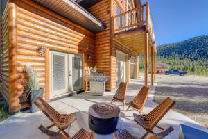 Brand New Idaho Springs Cabin with Patio and Fire Pit! في أيداهو سبرينغز: شرفة من كابينة خشبية مع كراسي وطاولة