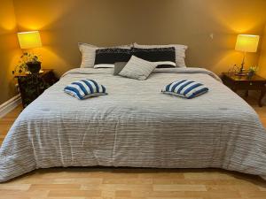a large bed with two blue and white pillows on it at Rustic Barn Style Romantic Getaway in Brampton