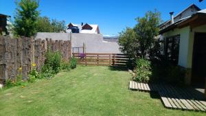 un patio trasero con una valla de madera y un patio en El Tranco - Casa "Tu Lugar" en Junín de los Andes