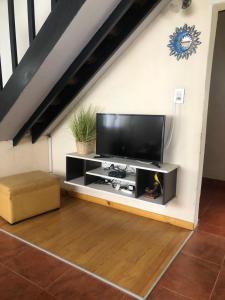uma sala de estar com uma televisão de ecrã plano na parede em El Tranco - Casa "Tu Lugar" em Junín de los Andes