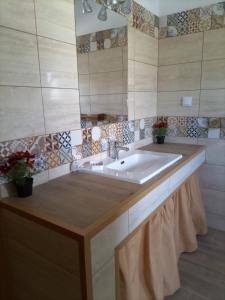 ein Badezimmer mit einem großen Waschbecken und einem Spiegel in der Unterkunft O Mundo da Lua in Azeitão