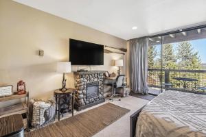 a bedroom with a bed and a fireplace and a balcony at Truckee Studio with Balcony and On-Site Skiing! in Truckee