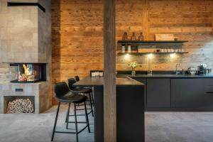 a kitchen with a bar and a fireplace at Chalet Amarou - OVO Network in Châtel