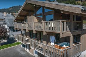 a large wooden house with a balcony and a pool at Chalet Amarou - OVO Network in Châtel