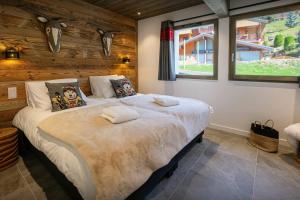 a bedroom with a large bed with two pillows at Chalet Amarou - OVO Network in Châtel