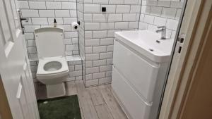 La salle de bains blanche est pourvue d'un lavabo et de toilettes. dans l'établissement House, à Londres
