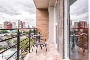 a balcony with tables and chairs and a view of the city at Stylish and modern Apt. with private balcony in Mexico City