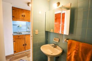 a bathroom with a sink and a toilet and a mirror at Center Bariloche in San Carlos de Bariloche