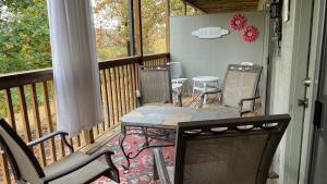 un porche cubierto con mesa y sillas en Cozy Comforts of Home, en Branson West