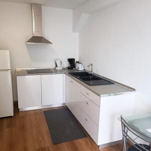 una cucina bianca con lavello e frigorifero di Casa Bela Vista Studio 1 a Ribeira Brava