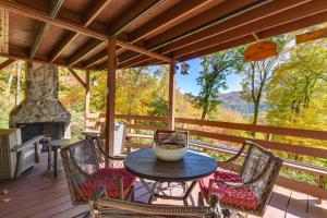 een tafel en stoelen op een veranda met een open haard bij Villa lAbri Magical Maggie Valley Escape! in Maggie Valley