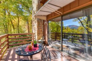 een patio met een tafel en stoelen op een balkon bij Villa lAbri Magical Maggie Valley Escape! in Maggie Valley