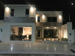 a large white house at night with a patio at Hotel Rg in Chivilcoy
