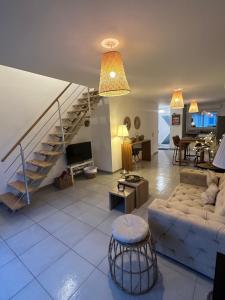a living room with a couch and a staircase at Le brise lame maison neuve à 2 pas de la plage in Le Portel