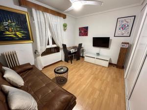 uma sala de estar com um sofá e uma mesa em Apartamento Entero al lado de calle de Alcalá em Madrid