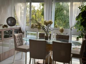 uma sala de jantar com uma mesa de vidro e cadeiras em Benalmádena em Benalmádena