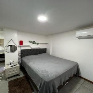 a bedroom with a bed and a mirror and a table at STUDIO 306 | WIFI 600MB | RESIDENCIAL JC, um lugar para ficar. in Belém