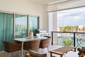 sala de estar con mesa y sillas en el balcón en Condominio de lujo en Cap Cana Marina!, en Punta Cana