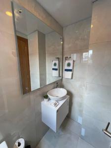 La salle de bains est pourvue d'un lavabo et d'un miroir. dans l'établissement Moderno apartamento en Naco, à Saint-Domingue