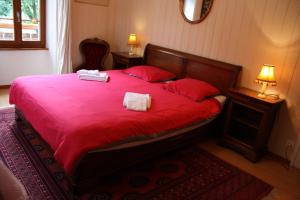 a bedroom with a red bed with two towels on it at La Petite Auberge in Versegeres 