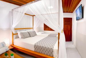 a bedroom with a canopy bed with white curtains at Hotel Jeri in Jericoacoara