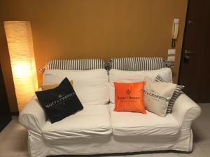 Un sofá blanco con tres almohadas. en Garden Wine Suite, en Verona