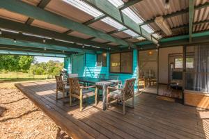 a patio with a table and chairs on a deck at Blue House Surf Shack - Pet Friendly in Lennox Head