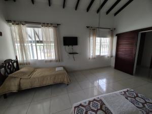a bedroom with two beds and a flat screen tv at Finca Bellavista in Ginebra