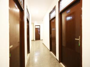 a hallway with brown doors in a building at OYO Flagship 44151 Royal Guest House in Garhi Harsāru