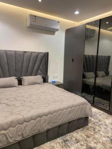 um quarto com uma cama grande e uma cabeceira cinzenta em وناسه مودرن em Riyadh