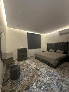 a bedroom with a bed and a flat screen tv at وناسه مودرن in Riyadh