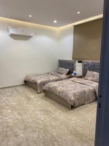 a bedroom with two beds and a air conditioner at وناسه مودرن in Riyadh