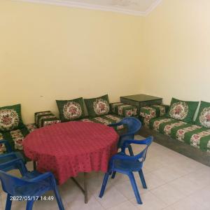 una camera con tavolo, sedie e divano di HOTEL NAGJIR PLAGE a Laayoune
