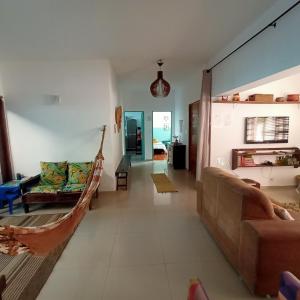 ein Wohnzimmer mit einem Sofa und einer Hängematte in der Unterkunft CASA SERENA - Piscina, Wi-fi e Conforto bem pertinho da praia in Itanhaém