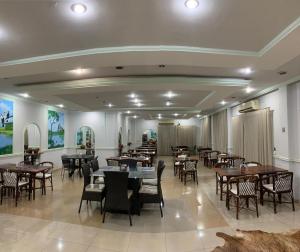 a restaurant with tables and chairs in a room at Marion Pantanal Hotel in Várzea Grande