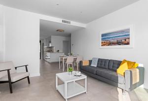 una sala de estar con un sofá y una mesa en Santiago Sunny Seaview Apartment, en Santiago de la Ribera