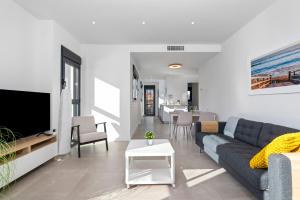 Una sala de estar con un sofá y un televisor. en Santiago Sunny Seaview Apartment, en Santiago de la Ribera