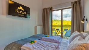 a bedroom with a bed with a tv on the wall at Apartamenty Karpatia Resort by ROYAL APARTS in Karpacz