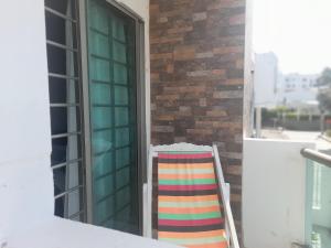 een kleurrijke stoel op een balkon naast een raam bij Acogedor apartamento Malala's in Sincelejo