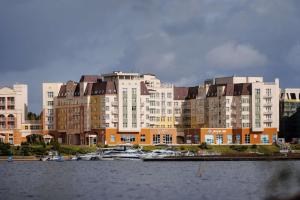 a large apartment building with boats in the water at Radisson Residences, Zavidovo in Zavidovo